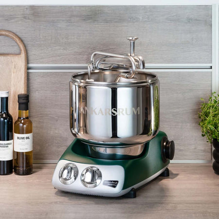 Ankarsrum stand mixer in forest green shown on a countertop.