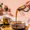 Dreamfarm Upcup adjustable measuring cup with oil.
